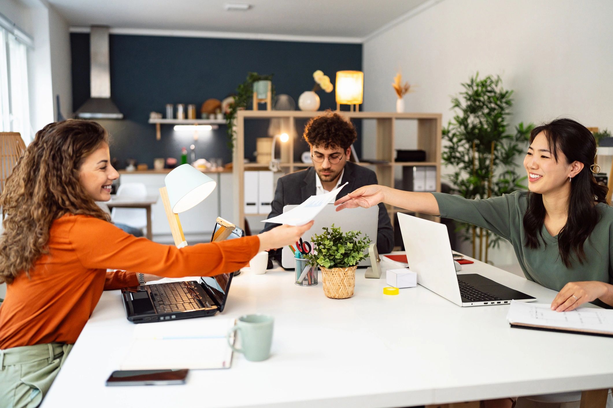 Two colleagues collaborating at a desk with a laptop